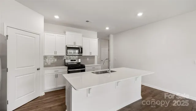 a kitchen with a sink a microwave a stove and refrigerator