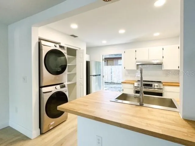 a kitchen with kitchen island a sink a stove and cabinets
