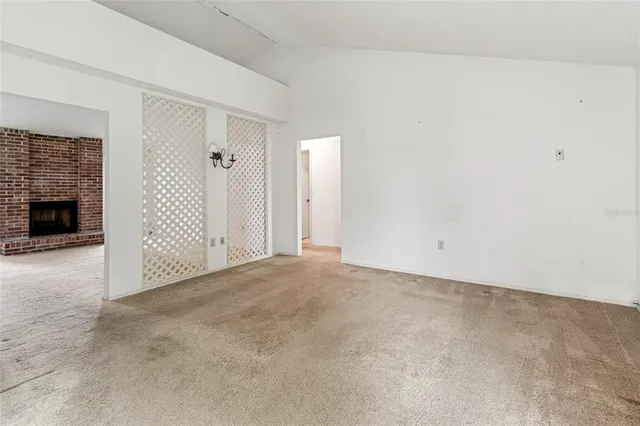 a view of a livingroom with a chandelier fan and windows