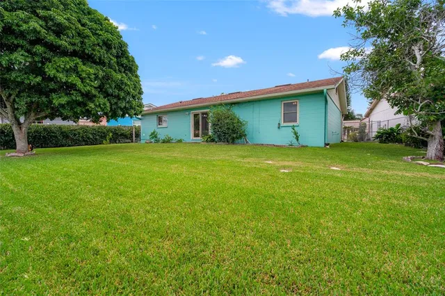 an aerial view of a house with swimming pool and outdoor seating