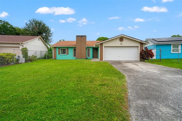 a view of a house with a yard and garage