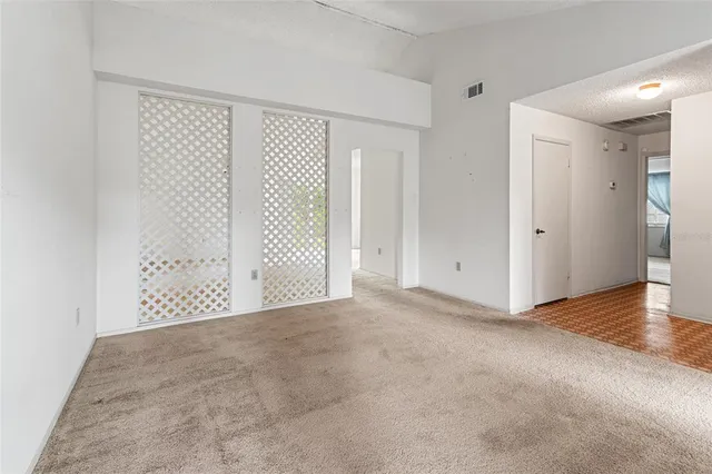 an empty room with windows and fan
