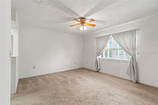 an empty room with closet and a chandelier fan