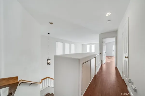 a hallway with white cabinets and wooden floor
