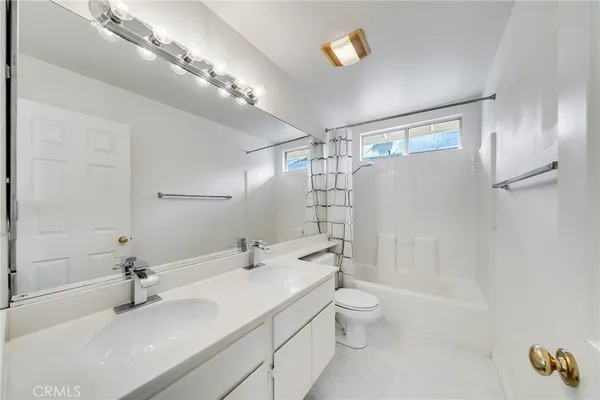 a bathroom with a granite countertop sink a toilet and shower