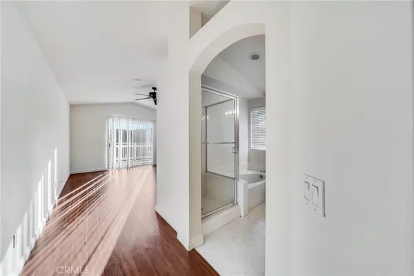 a view of a hallway with wooden floor and a living room