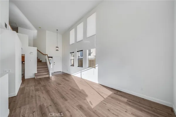 a view of empty room with wooden floor and window