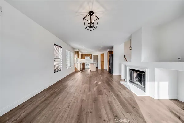 a view of empty room with wooden floor and fireplace
