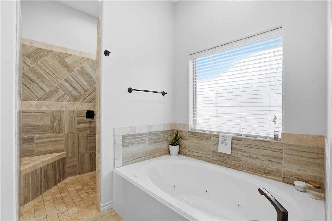 3516 Foxcroft Path Bryan, TX 77808 - Photo 18 of 38 a bathroom with a bathtub and a shower