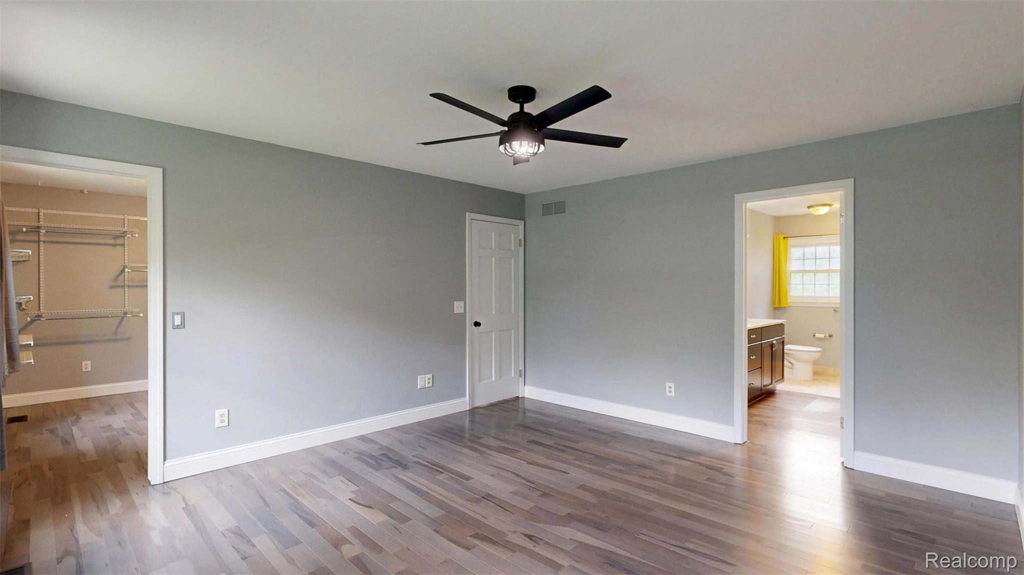 10300 Clark Road Davisburg, MI 48350 - Photo 18 of 39 Unfurnished bedroom featuring a walk in closet, dark wood-style floors, and ceiling fan