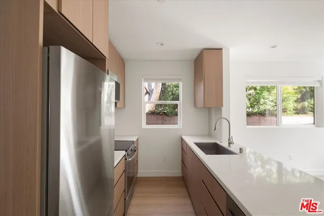 a kitchen with stainless steel appliances granite countertop a refrigerator and a sink