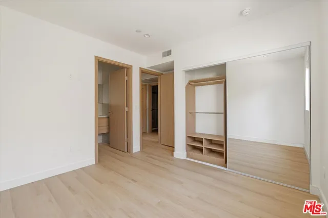an empty room with wooden floor and door