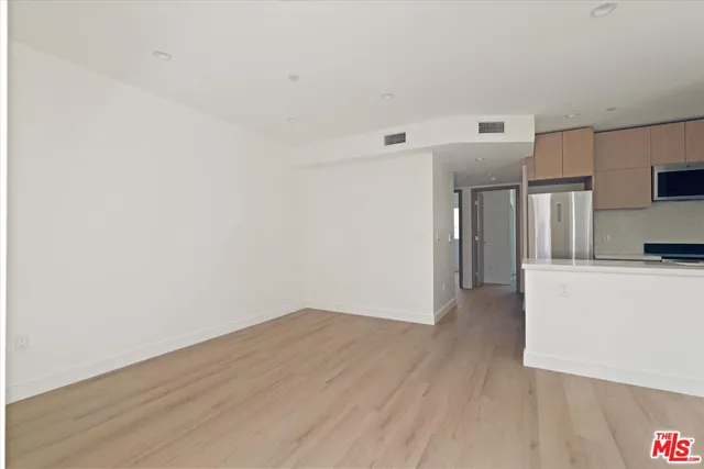 a view of a kitchen with wooden floor and a sink
