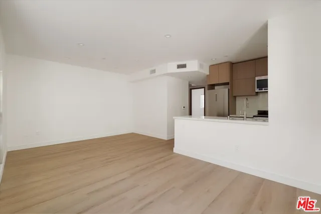 a view of a big room with wooden floor and cabinets