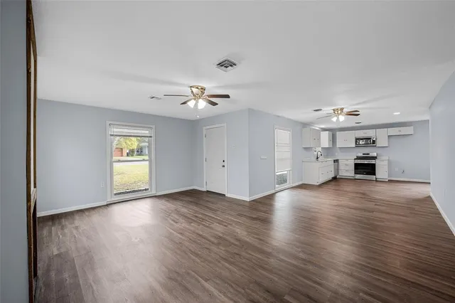 a kitchen with stainless steel appliances white cabinets granite counter tops and a window