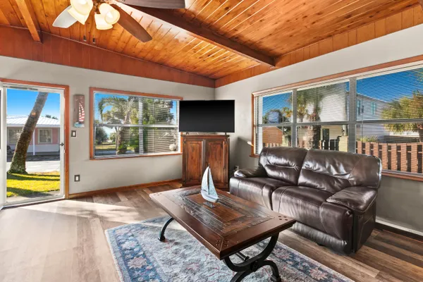 a living room with furniture a flat screen tv and kitchen view