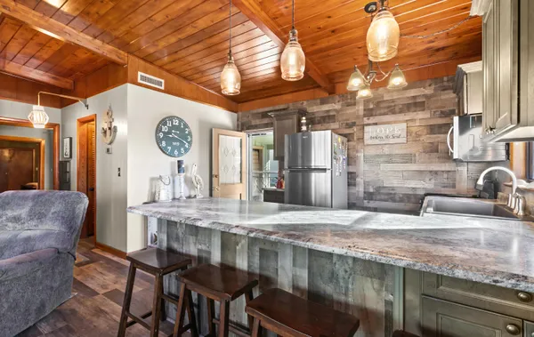 a kitchen with stainless steel appliances granite countertop a refrigerator a sink and a stove