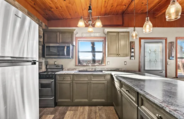 a open kitchen with stainless steel appliances granite countertop a sink and wooden cabinets