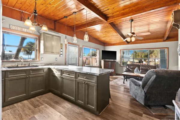 a kitchen with granite countertop a sink stove and cabinets