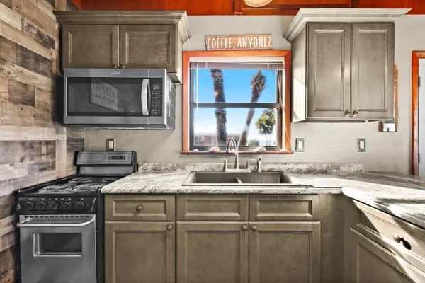 a large kitchen with a large counter space a sink and cabinets