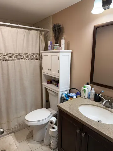 a bathroom with a granite countertop sink toilet and mirror