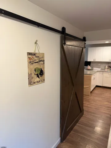 a view of a hallway with wooden floor and entryway
