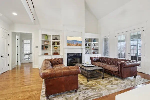 a view of kitchen with stainless steel appliances wooden floor dining table and chairs