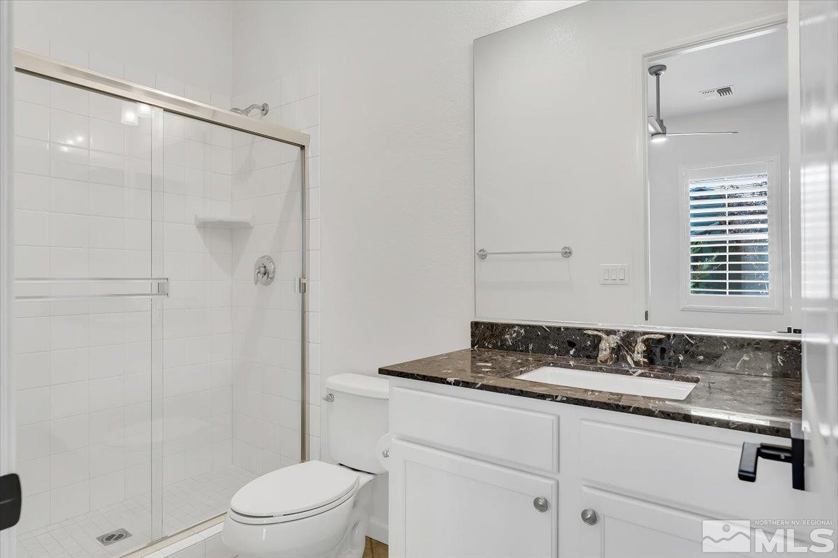 9405 Baldacci Road Reno, NV 89521 - Photo 32 of 40 a bathroom with a granite countertop sink toilet a mirror and shower