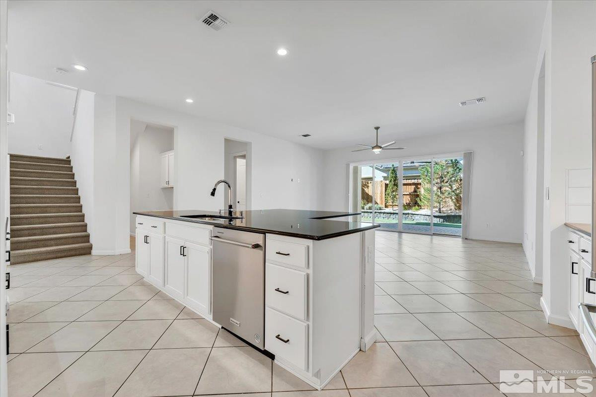 9405 Baldacci Road Reno, NV 89521 - Photo 9 of 40 a kitchen with granite countertop white cabinets and white appliances