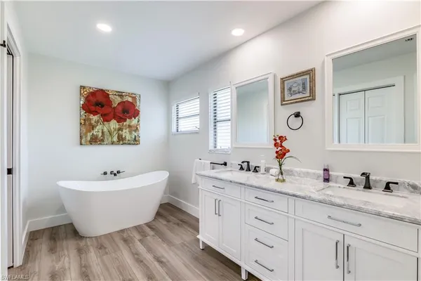 a bathroom with a double vanity sink mirror and bathtub