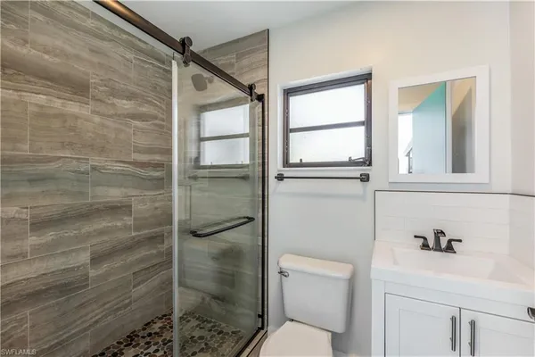 a bathroom with a shower a toilet and a sink