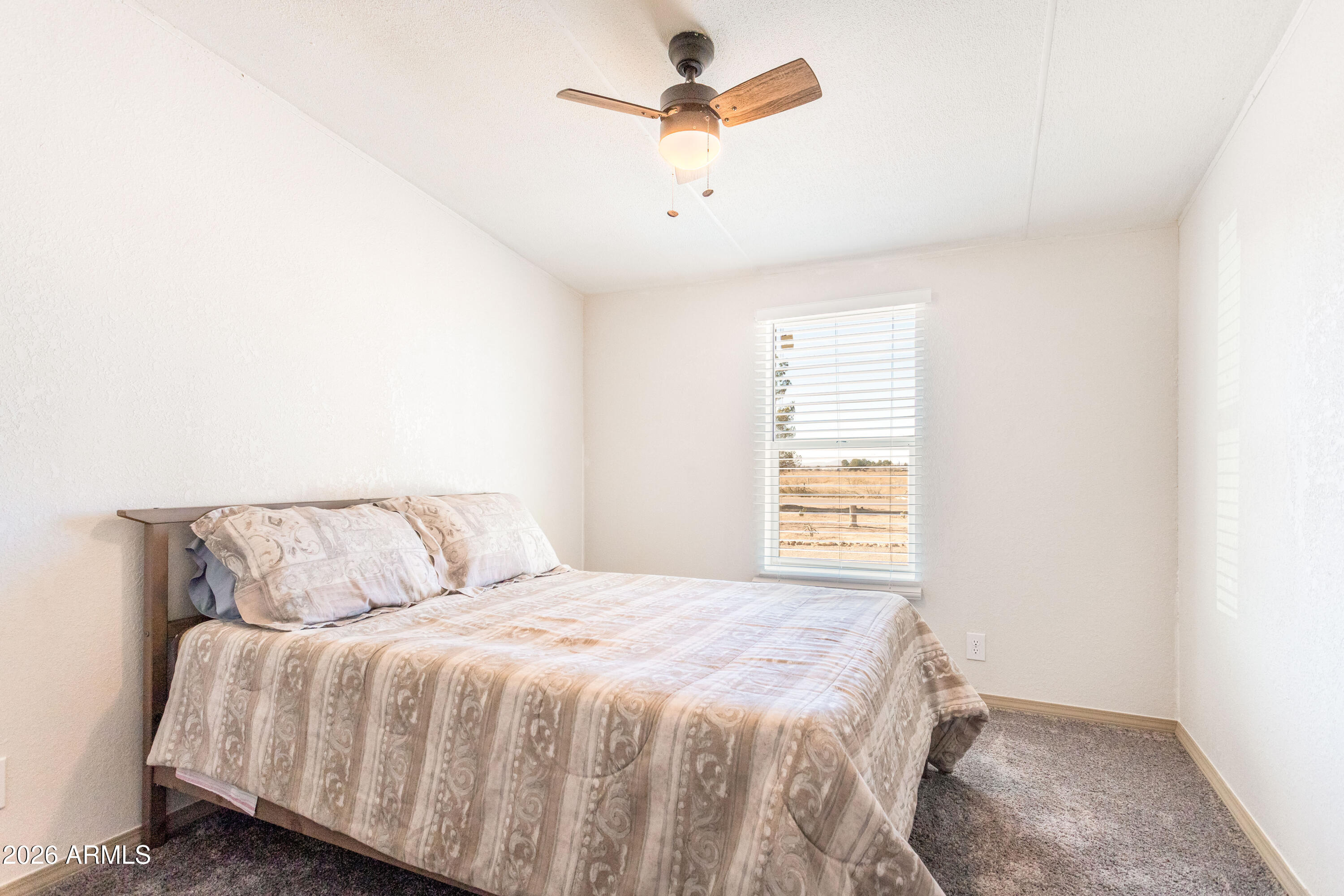 10405 North Mormon Road Elfrida, AZ 85610 - Photo 27 of 43 a bedroom with a bed and a ceiling fan