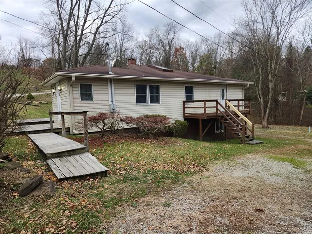 a backyard of a house with barbeque oven table and chairs
