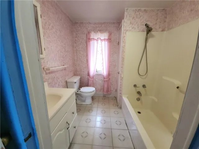 a bathroom with a bathtub shower sink vanity and toilet