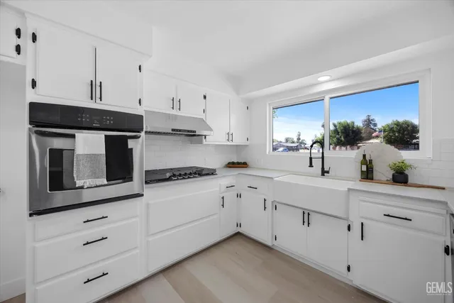 a kitchen with cabinets stainless steel appliances and sink