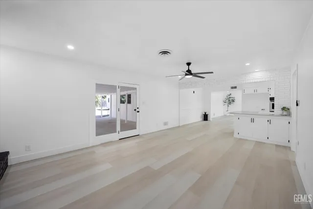 an empty room with a cabinet and mirrors