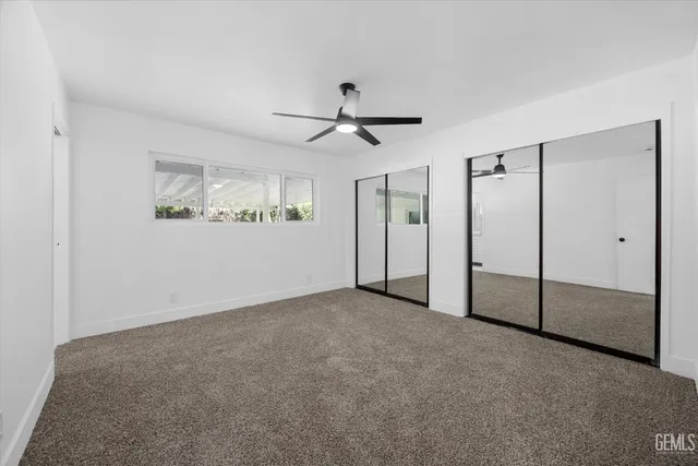 an empty room with fan and windows