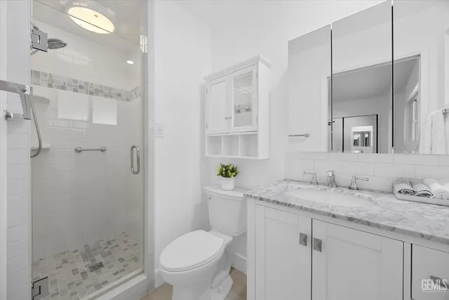 a bathroom with a granite countertop sink toilet and shower