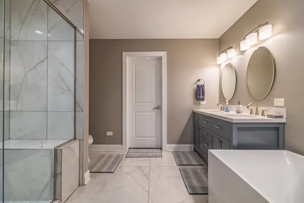a spacious bathroom with a tub sink and mirror