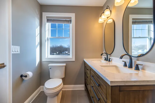 a bathroom with a toilet sink and mirror