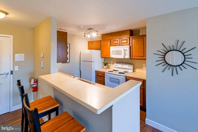 a kitchen with stainless steel appliances a stove a refrigerator and a dining table