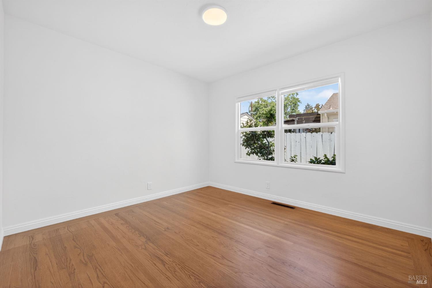 2211 Humboldt Street Santa Rosa, CA 95404 - Photo 31 of 52 an empty room with wooden floor and windows