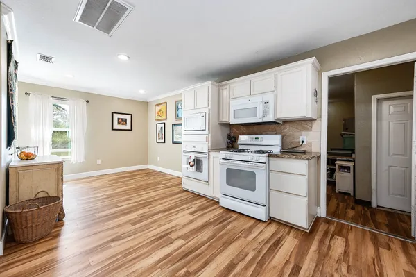 a kitchen with granite countertop a stove top oven and cabinets