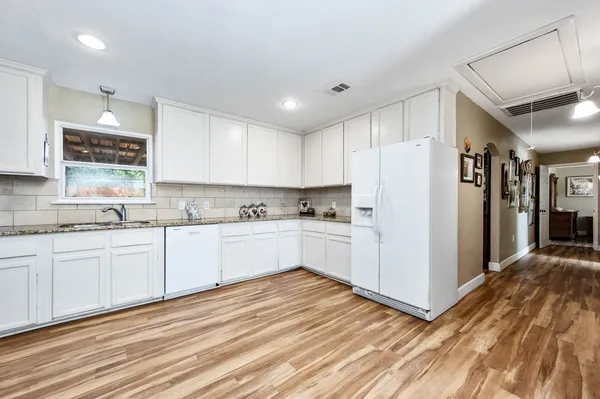 a kitchen with granite countertop white cabinets and white appliances