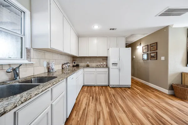 a kitchen with white cabinets sink and stainless steel appliances