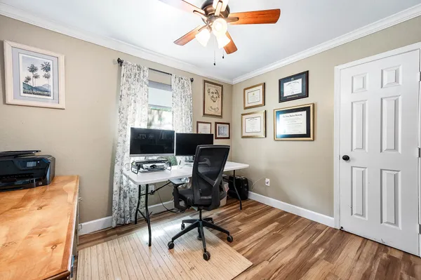 a view of a workspace with wooden floor and a window
