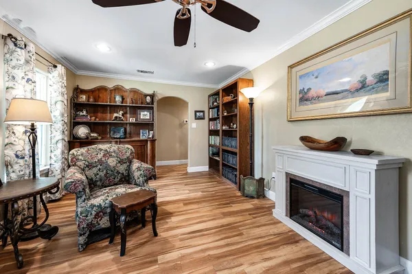 a living room with furniture a rug and a bookshelf