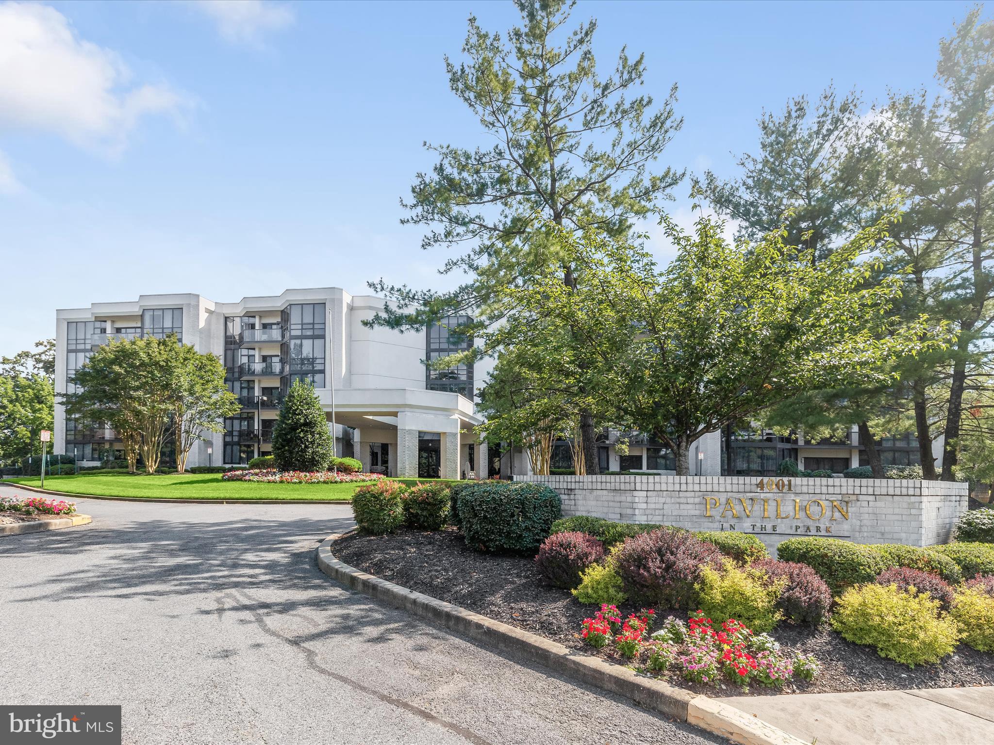 a front view of a house with a garden and trees