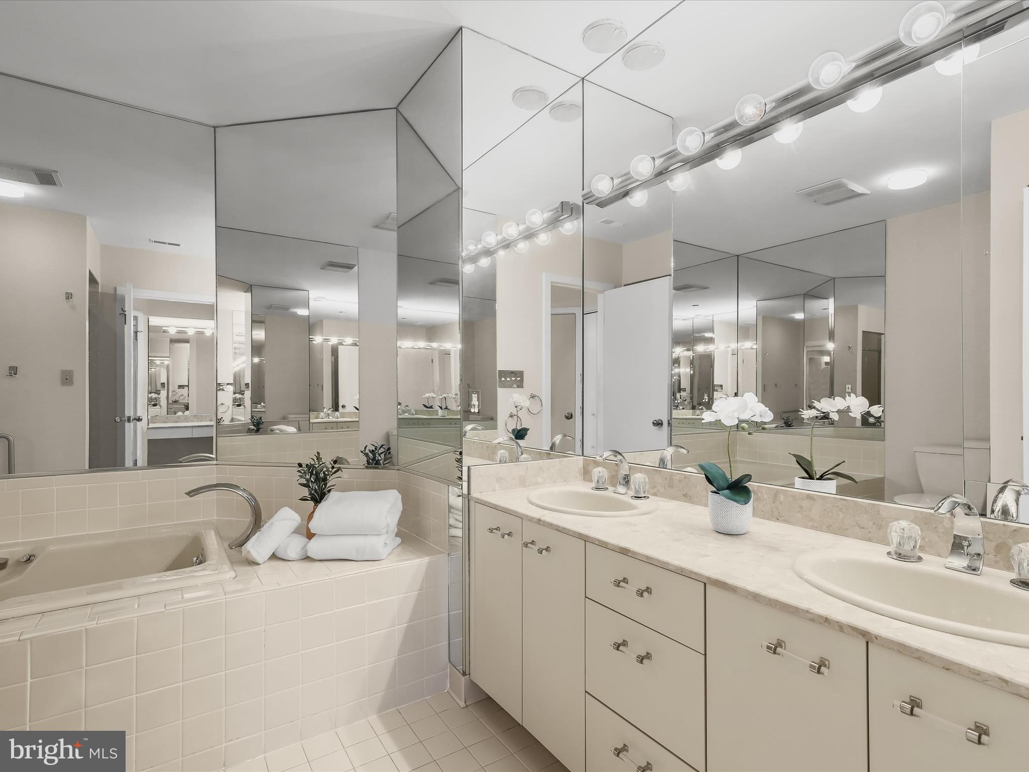 4001 Old Court Road, Unit 519 Pikesville, MD 21208 - Photo 29 of 43 a bathroom with a double vanity sink a mirror a bathtub and shower