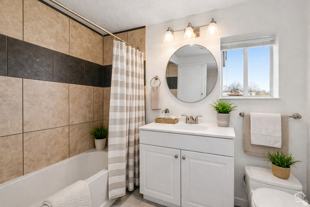 25615 Main Street Portage, UT 84331 - Photo 10 of 42 Bathroom with vanity, shower / tub combo with curtain, and a textured ceiling
